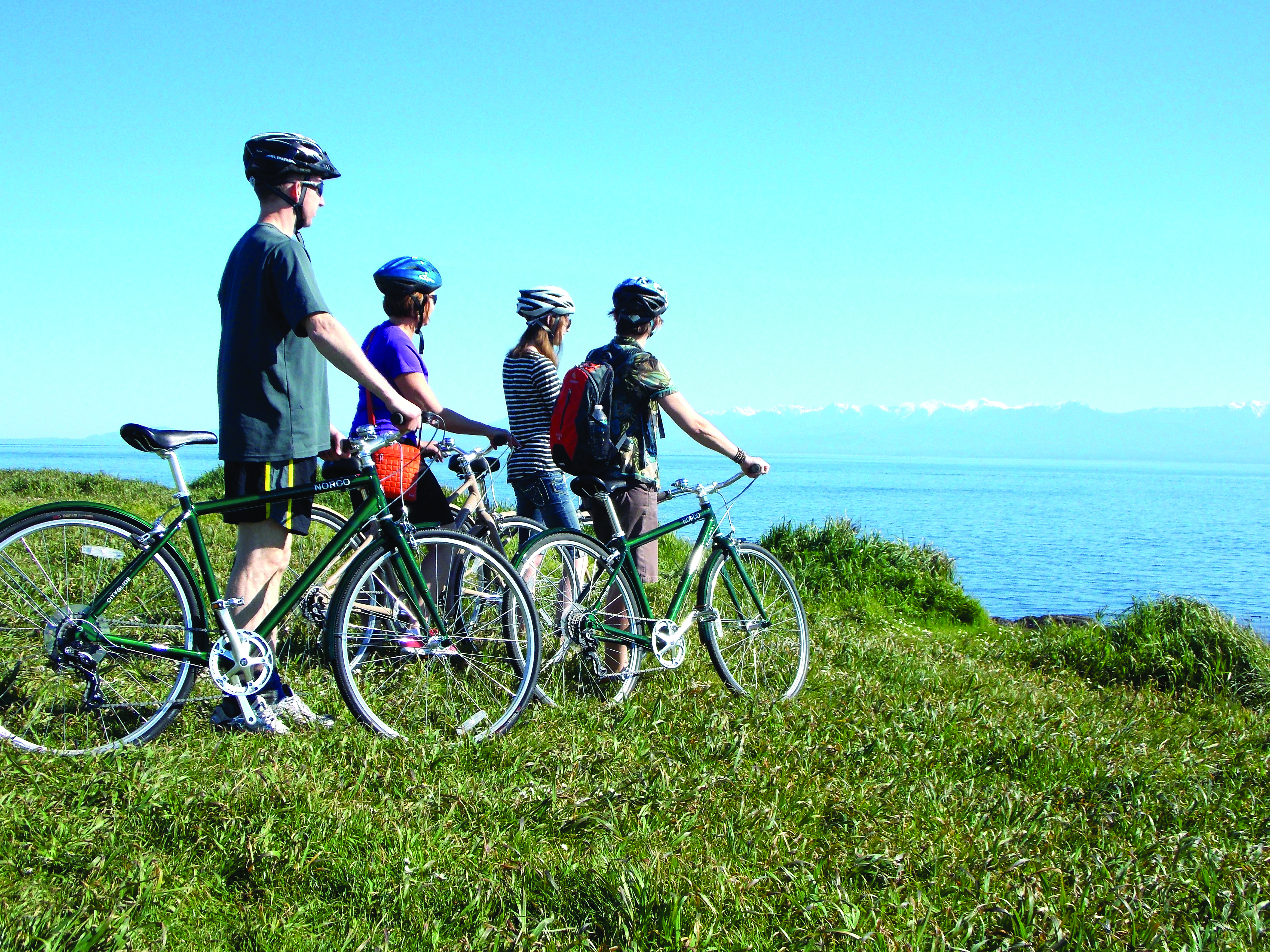 Bikers looking out to sea, part of an outdoor adventurer's getaway in Victoria. Photo courtesy of Pedaler Tours